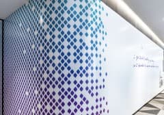 A gradient pattern of small dots vinyl-wrapped around a locker bank corridor.