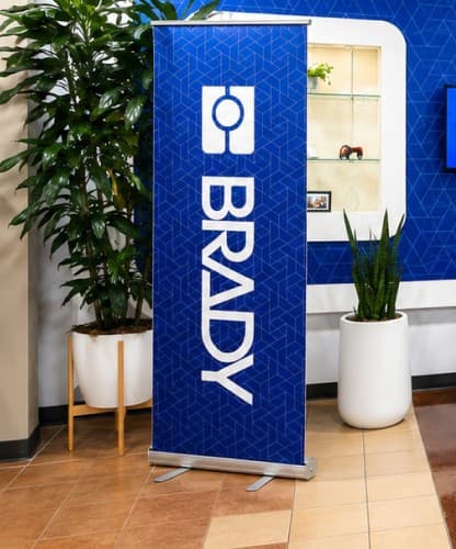A branded Brady banner stand in the lobby, beside a display niche.