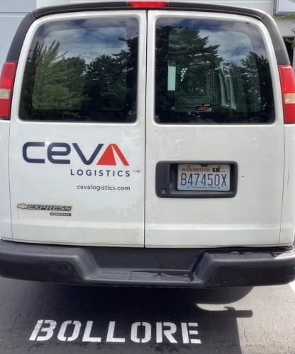 The rear of a CEVA Logistics delivery van, parked over faded Bolloré road markings