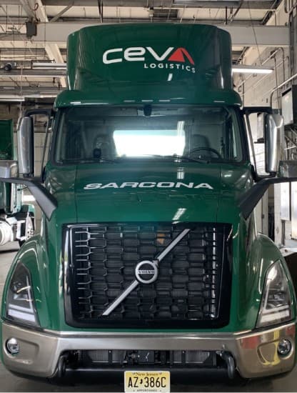 A green CEVA Logistics tractor unit inside a maintenance depot
