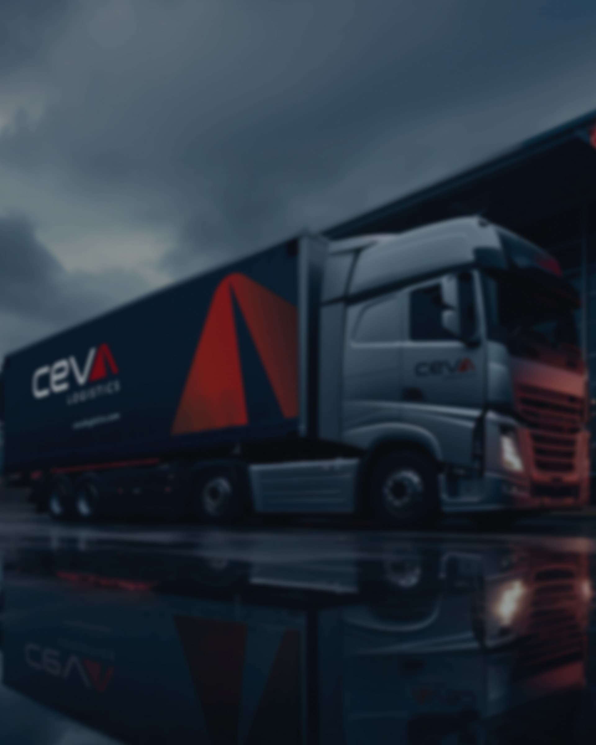 A CEVA Logistics lorry in the new livery parked under a stormy sky, reflected in the wet ground beneath it.