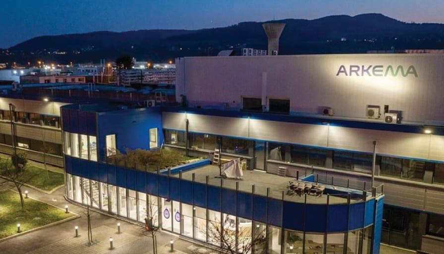 An Arkema site at dusk, the wordmark lit high on the building.