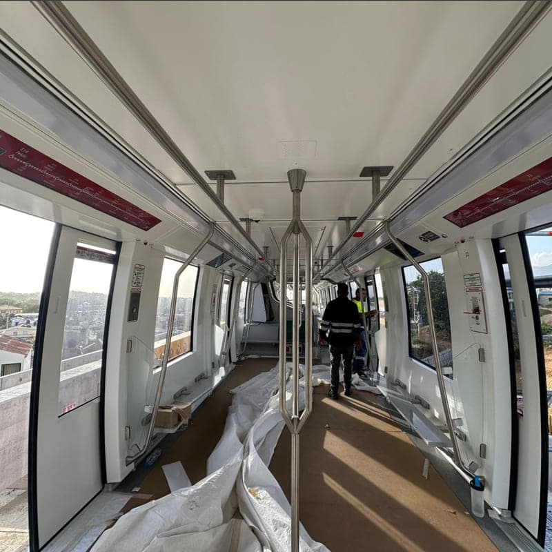 The gangway of an Alstom metro car during fit-out, protective sheeting still laid down the centre of the floor.