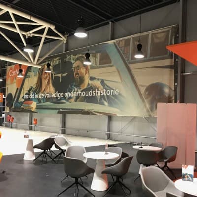 A CarNext showroom mural promoting full maintenance-history visibility, seating arranged beneath it.