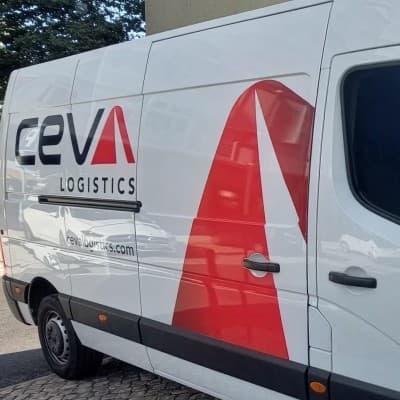 A CEVA Logistics delivery van in the new white and red livery, parked at a site outside France.