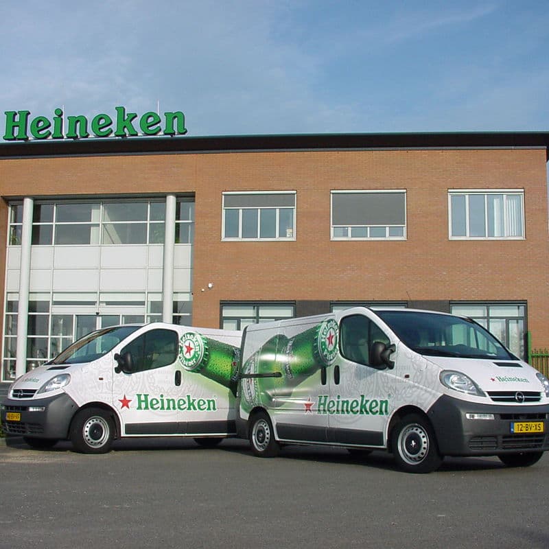 Two Heineken service vans outside a Heineken-branded distribution building.