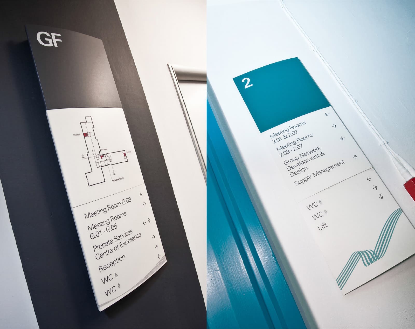 Two floor directory signs side by side, a gray ground-floor panel and a teal second-floor panel listing meeting rooms.