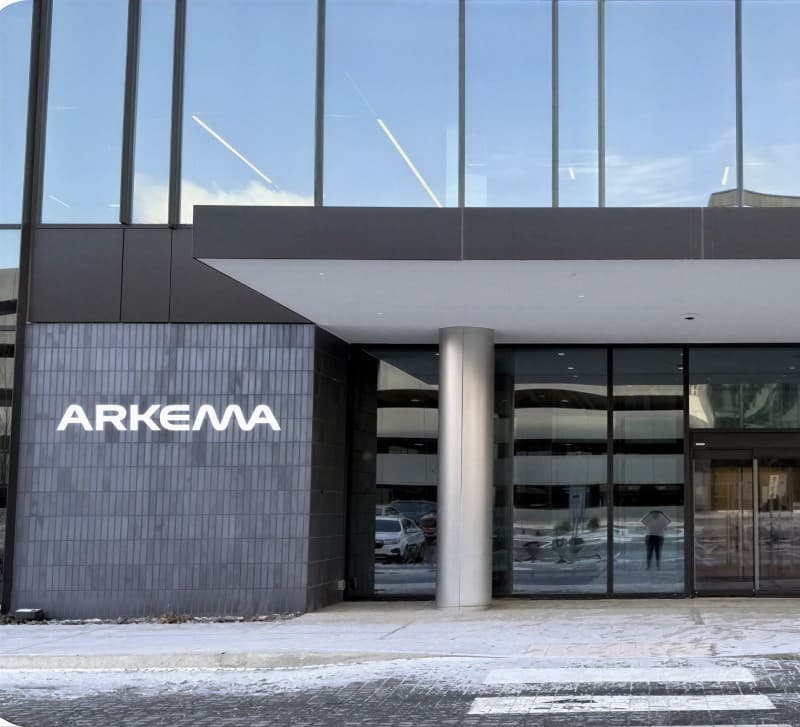 The Arkema wordmark on a grey block fascia above a site entrance canopy.