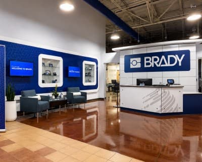 Brady’s reception feature wall - a patterned blue panel with display niches and digital screens.