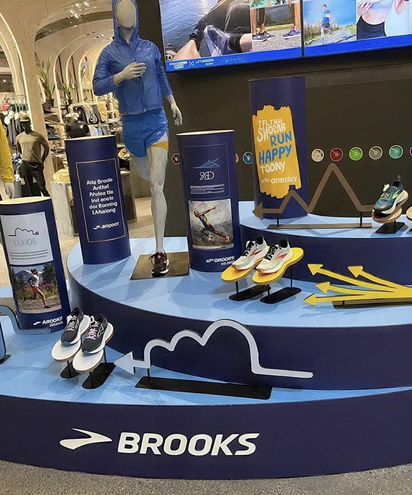A Brooks running display with footwear and apparel arranged on a circular branded platform.