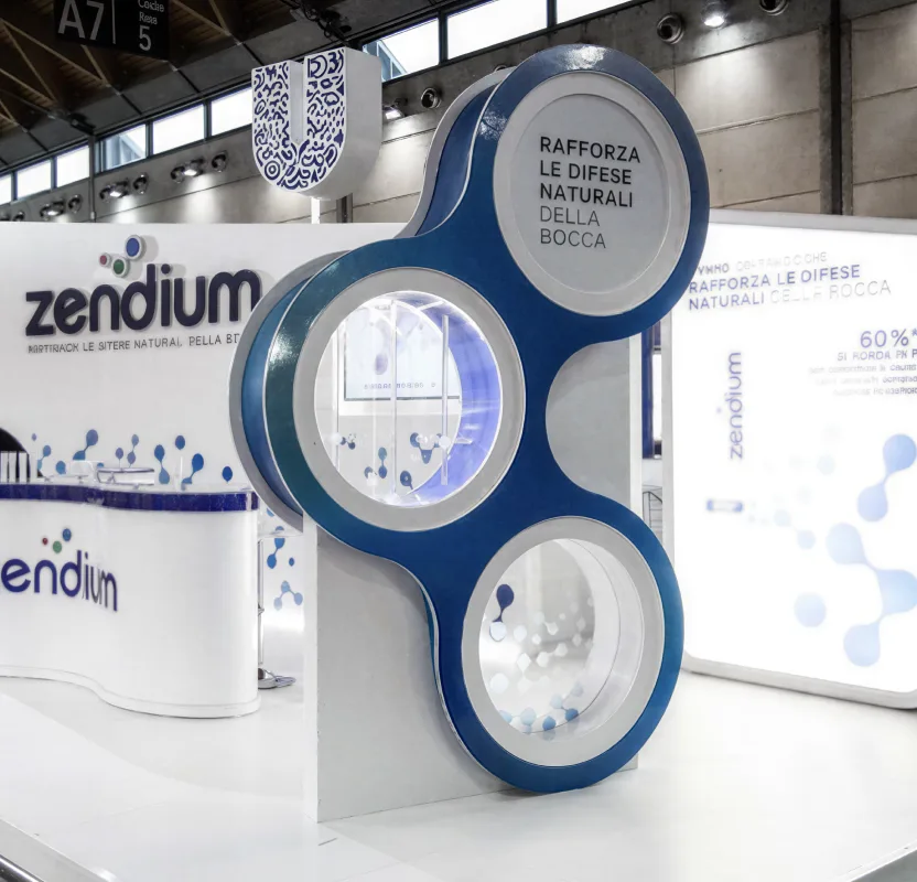 A Zendium exhibition stand with a large backlit product sculpture at its centre.