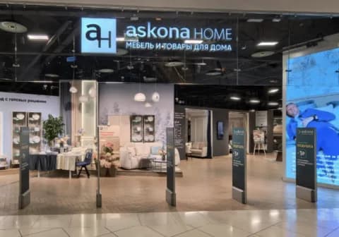 An askona HOME store entrance inside a shopping center, under an illuminated fascia sign